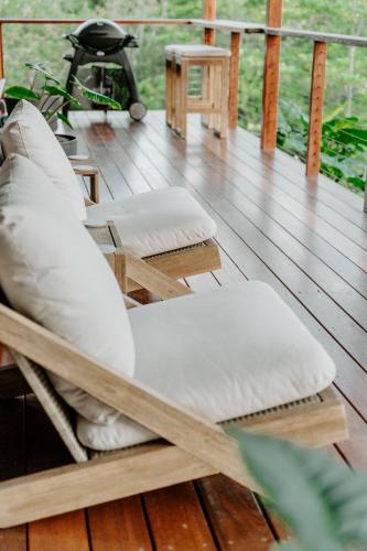 a wooden deck with a chair and a desk at Waterfall Lodge in Carool
