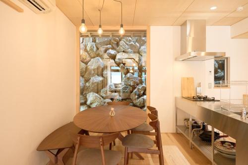 Ochi的住宿－Carpe Diem Kamaida，一间设有木桌和石墙的用餐室