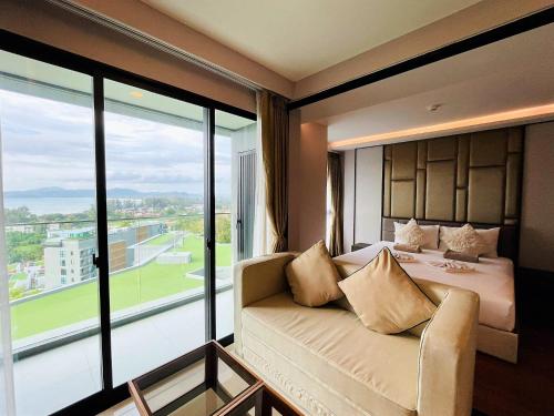 Habitación de hotel con cama y ventana grande en Private sea view apartment at Mida Grande Resort, en Surin Beach
