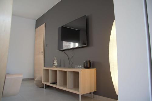 a living room with a tv and a shelf with a television at Gîte du Lac Cosy in Fosses-La-Ville