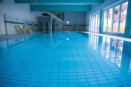 a swimming pool with a blue tile floor and blue tile floorsktop at Schlosspark Grubhof - Mitterer in Sankt Martin bei Lofer