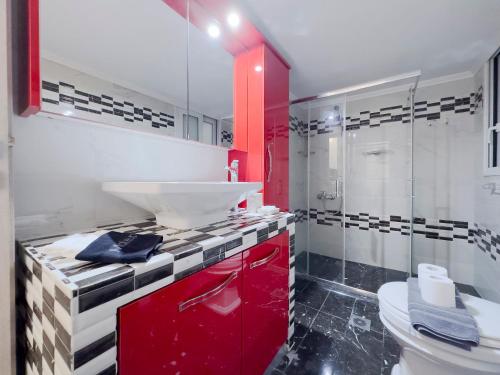 baño con lavabo rojo y aseo en Aristotelous Spacious 109sqm apt in Athens en Athens