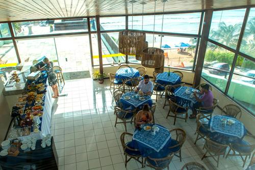 a group of people sitting at tables in a restaurant at BLUE MARLIN 09 PONTA NEGRA in Natal
