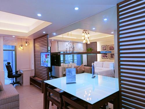 un soggiorno con tavolo e divano di Two Palmtree Villas Across Manila Airport Terminal 3 -JJRMK Condotel a Manila