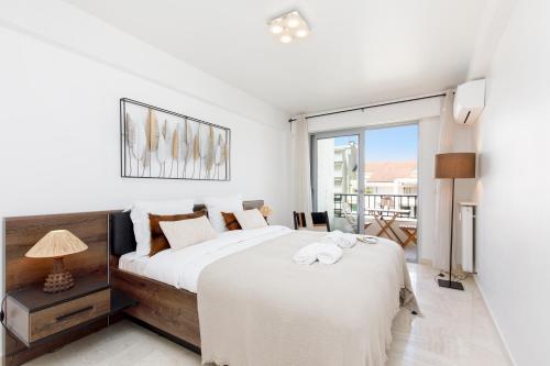 une chambre avec un grand lit et un balcon dans l'établissement Royal Palm YourHostHelper, à Cannes
