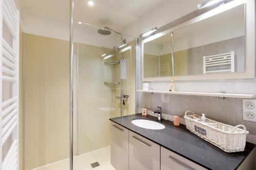 a bathroom with a sink and a glass shower at Royal Palm YourHostHelper in Cannes