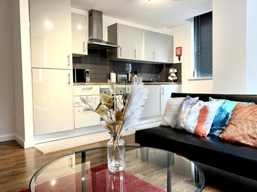 a living room with a black couch and a glass table at Captivating 2-Bed Apartment in Bedford in Bedford