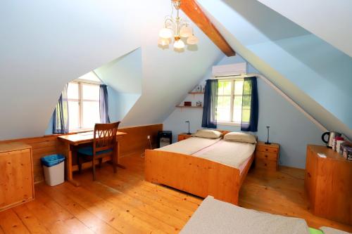 um quarto com uma cama e uma secretária num sótão em Homestay Vito by Lake em Bled