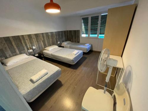 um quarto de hospital com duas camas e uma ventoinha em Pensión La Estrella em Zaragoza