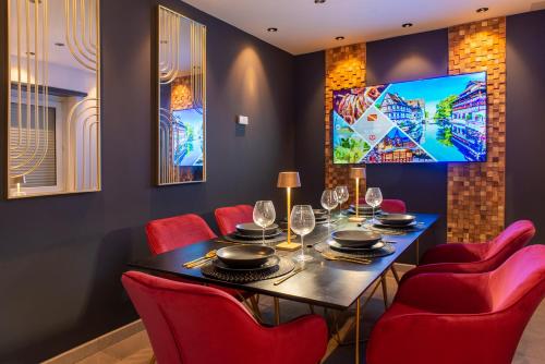 uma sala de jantar com uma mesa e cadeiras vermelhas em Gîte au coeur de l'Alsace Maison Gatsby em Staffelfelden
