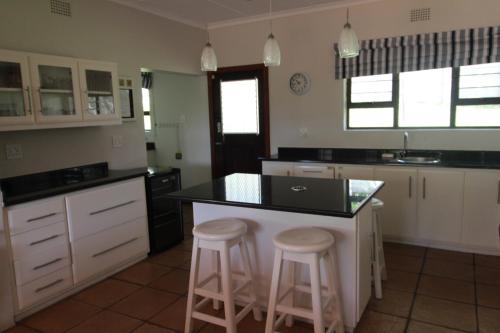 a kitchen with a island with two stools in it at Seagull Road 838 in Margate