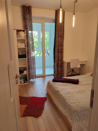 a bedroom with a bed and a desk and a window at Desafinado in Burgas City