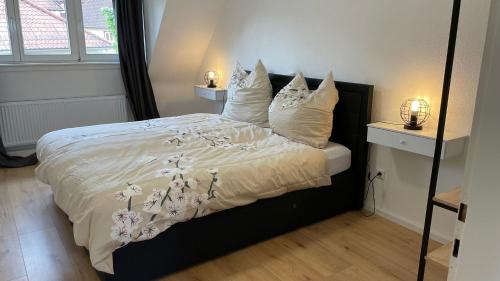 una camera da letto con letto, lenzuola e cuscini bianchi di Fewo- Daniela a Hauenstein