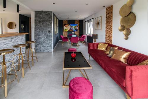 un salon avec un canapé rouge et une table dans l'établissement Gîte au coeur de l'Alsace Maison Gatsby, à Staffelfelden