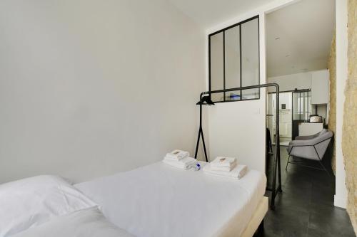 - une chambre avec un lit blanc et une chaise dans l'établissement CMG Louis Blanc - Gare de l'Est, à Paris
