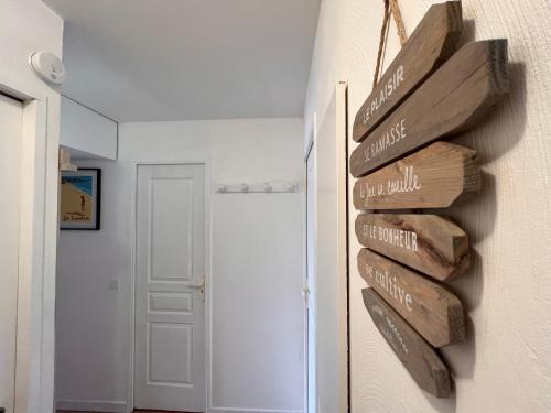 a room with a bunch of wooden signs on the wall at Vacances, thalasso, télétravail dans superbe T3 mer à 100 m, centre à 400 m in Les Issambres