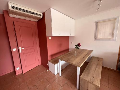 a kitchen with a red door and a table and a red door at Vacances, thalasso, télétravail dans superbe T3 mer à 100 m, centre à 400 m in Les Issambres