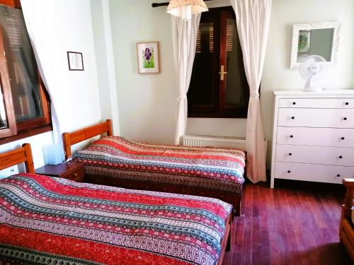a bedroom with two beds and a dresser at Litani House in Raches