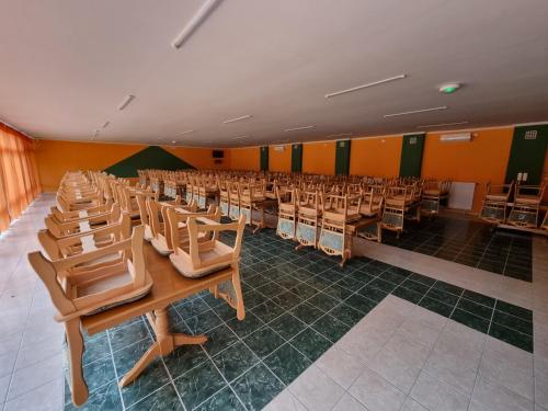 an empty room with rows of chairs and desks at Zöldsziget Menedék, Rendezvény-és pihenőház in Bárna