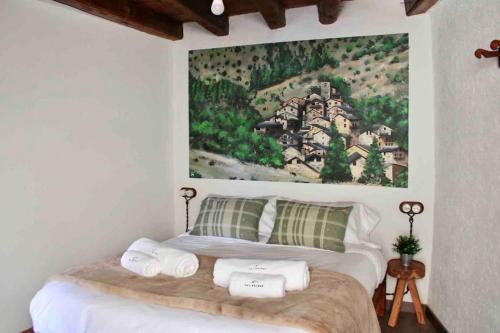 a bedroom with a bed with a painting on the wall at CAL SOLDAT in Os de Civís