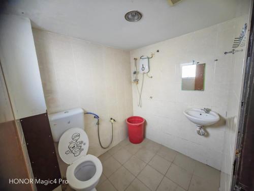 a bathroom with a toilet and a sink at Melawati Ria Hotel in Kuala Selangor