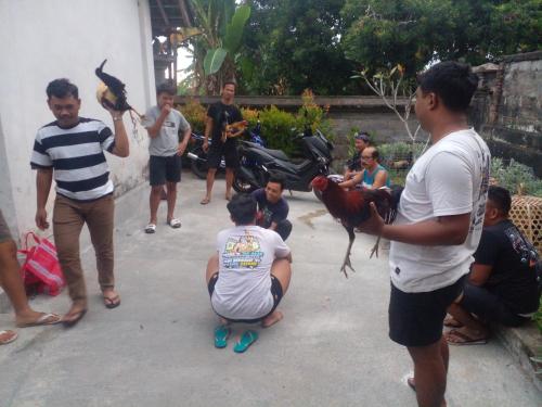 a group of people standing around a man holding a bird at Umah Desa in Banjarangkan