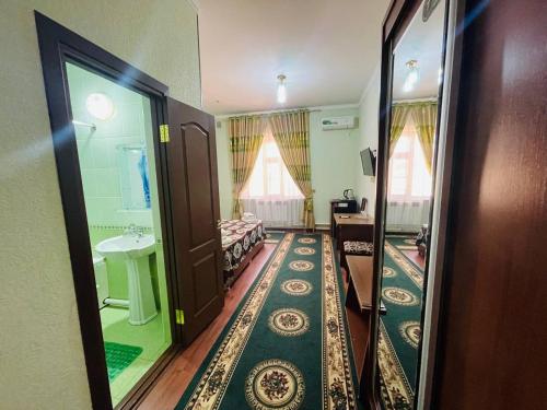 um pequeno quarto com uma cama e um espelho em Shokhjakhon Parvoz em Khiva