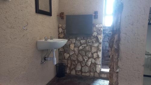 a bathroom with a sink and a stone wall at 4BFarming Rest camp and Camping in Naris