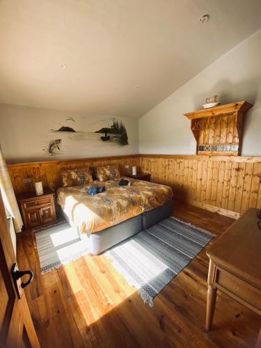 a bedroom with a bed and a wooden floor at Dulrush Self-Catering Lodges in Belleek
