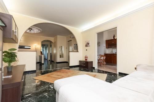 ein Wohnzimmer mit einem weißen Sofa und einer Küche in der Unterkunft Oasi di pace a 10 min. dall'aeroporto in Genua