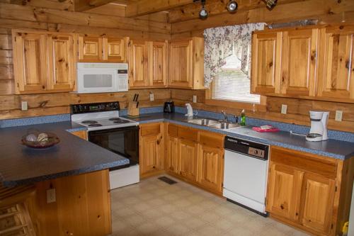 a kitchen with wooden cabinets and a stove top oven at 23 The Cub House Cabin in Gatlinburg