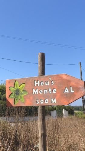 a wooden sign on a pole in a field at Heu’s Monte in Odemira