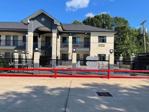 a building with a red fence in front of it at Days Inn by Wyndham Dickinson TX in Dickinson