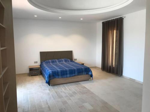 Schlafzimmer mit einem Bett mit blauer Decke in der Unterkunft Villa Houmet Souk in Houmt Souk