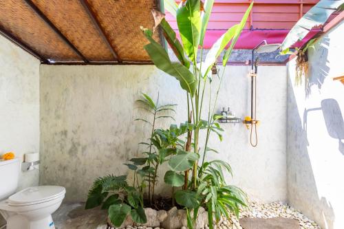 La salle de bains est pourvue de toilettes et de plantes. dans l'établissement Pondok pina ubud, à Ubud