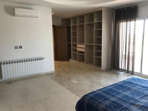 a bedroom with a bed and shelves and a window at Villa Houmet Souk in Houmt Souk