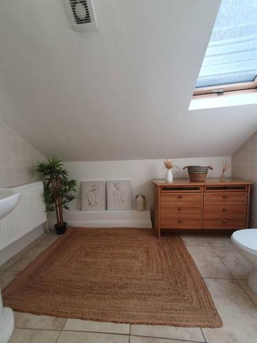 a bathroom with a sink and a table and a rug at Loft Apartment near Harry Potter Coaches in Watford