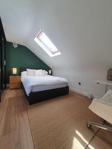 a bedroom with a bed and a green wall at Loft Apartment near Harry Potter Coaches in Watford