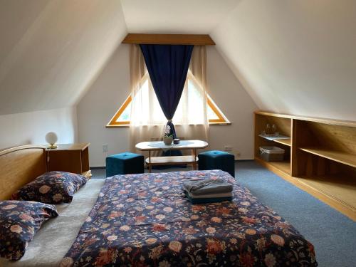 1 dormitorio con cama, mesa y ventana en Samoobslužný hotel Vydra en Srní