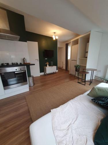 a living room with a bed and a kitchen at Loft Apartment near Harry Potter Coaches in Watford
