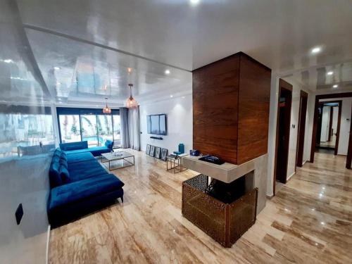 Una sala de estar con un sofá azul y una chimenea. en Cosy Urban, en Tamaris