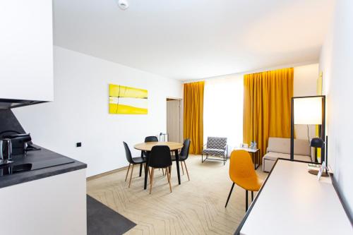 a kitchen and living room with a table and chairs at Arche Hotel Krakowska in Warsaw