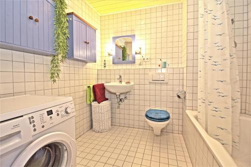 W łazience znajduje się toaleta, umywalka i pralka. w obiekcie Ferienwohnung KAKADU Apartment Dresden Laubegast WLAN TV Fahrrad w Dreźnie