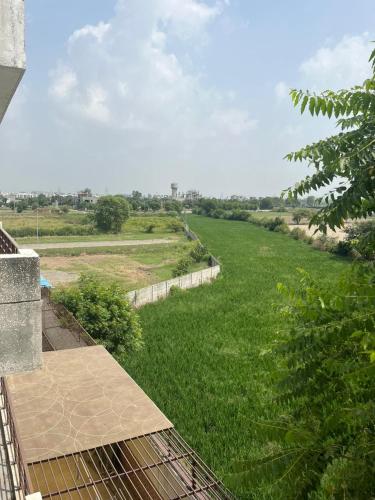 a view of a green field from a balcony at Yb home in Sonīpat