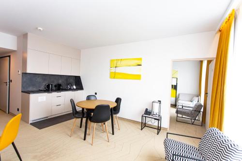 a kitchen and living room with a table and chairs at Arche Hotel Krakowska in Warsaw