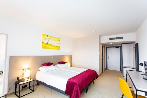 a bedroom with a large white bed and a desk at Arche Hotel Krakowska in Warsaw