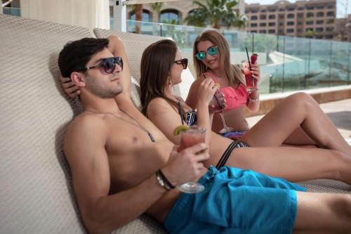 a group of three people sitting on a couch at Hilton Dead Sea Resort & Spa in Sowayma