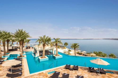 a view of the pool at a resort with palm trees at Hilton Dead Sea Resort & Spa in Sowayma