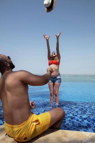 a man and a woman playing volleyball in the water at Hilton Dead Sea Resort & Spa in Sowayma