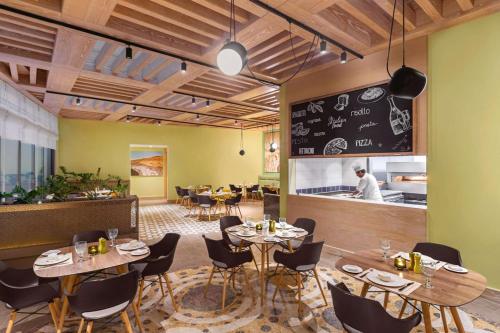 a restaurant with tables and chairs and a chef in the kitchen at Hilton Dead Sea Resort & Spa in Sowayma